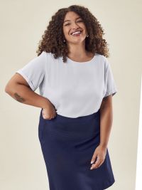 Weiße Damen-Chiffonbluse mit kurzem Arm, fließendem Stoff und modernem T-Shirt-Schnitt für Business und Service.